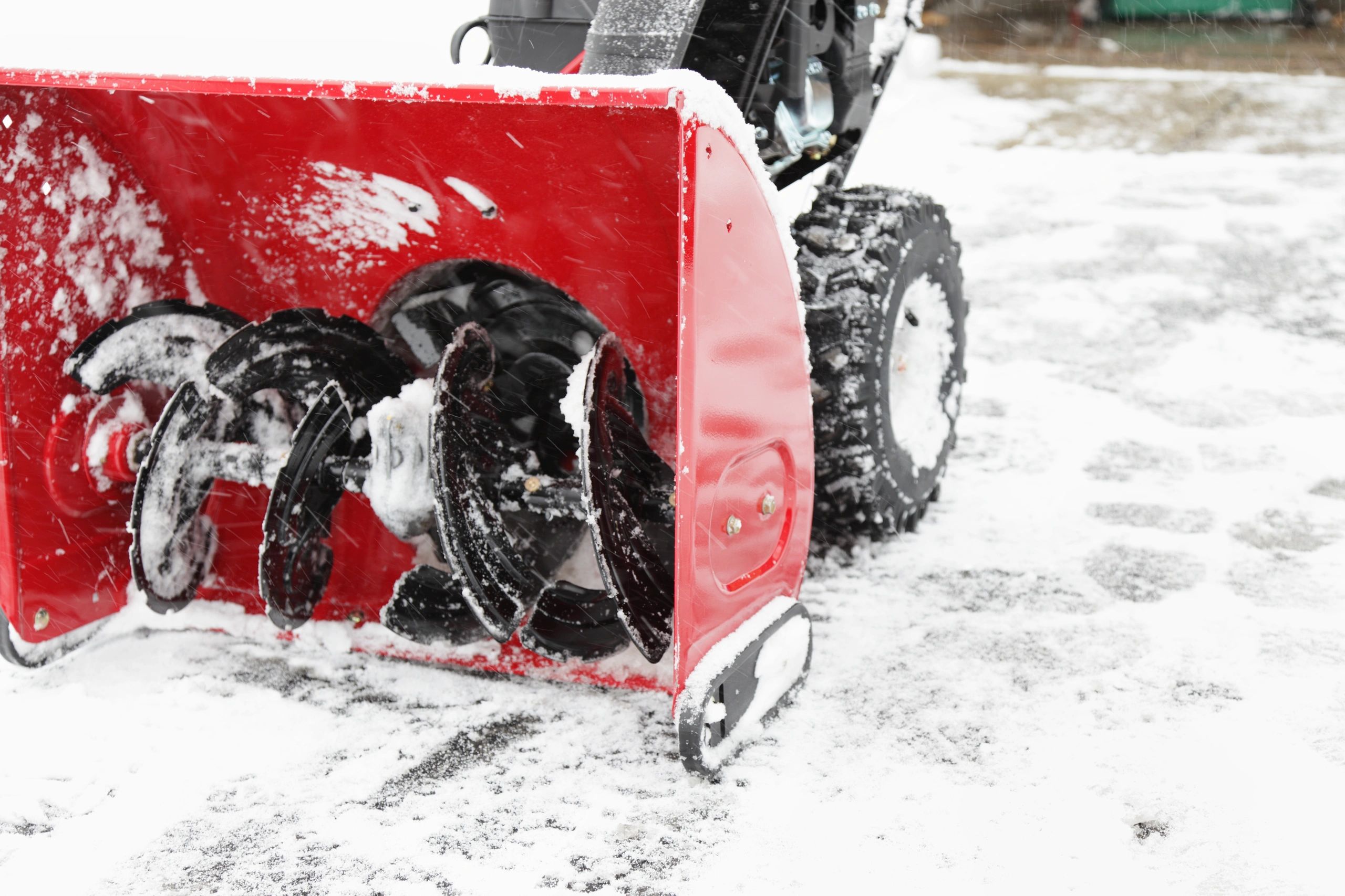 Snowblower clearing a driveway during a winter storm
